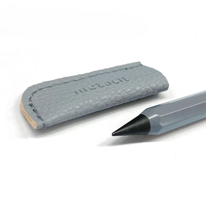 Close-up of the Sun-Star Metacil Metal Pencil Pocket with sharpened metal tip next to its textured leather protective cap.