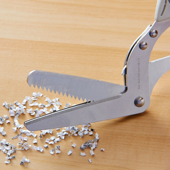 Sun-Star Triple Blade Shredder Scissors cutting paper into fine shredded strips on a wooden surface.