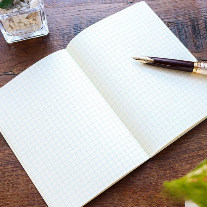 Open Tomoe River A6 softcover notebook showing squared pages.
