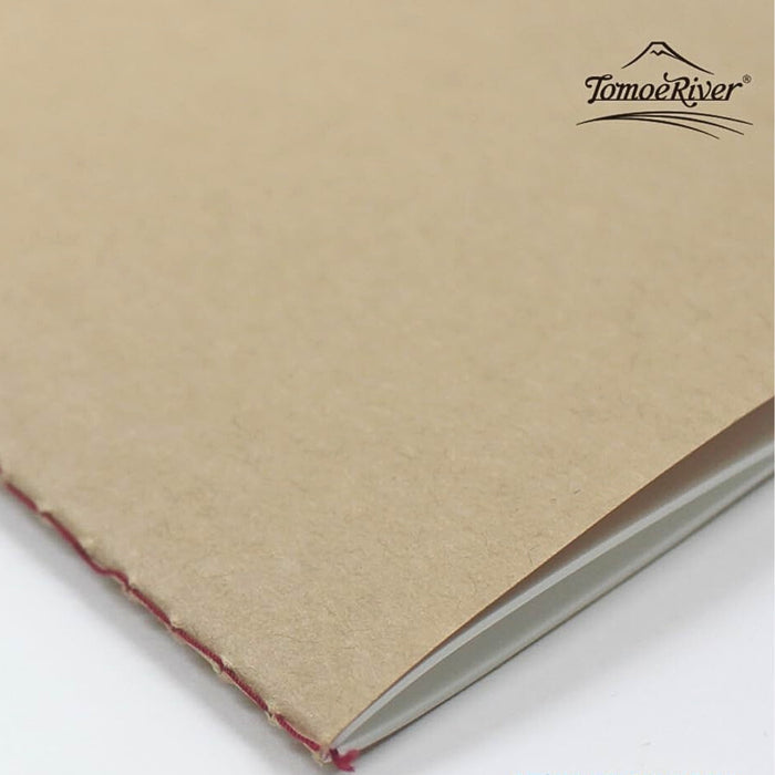 Angled view of the Sakae A5 plain stitch notebook showing stitched binding and kraft cover texture.