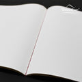 Flat lay of the Sakae A5 stitch notebook opened to show smooth, unlined plain paper.