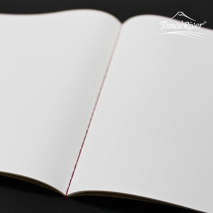 Flat lay of the Sakae A5 stitch notebook opened to show smooth, unlined plain paper.