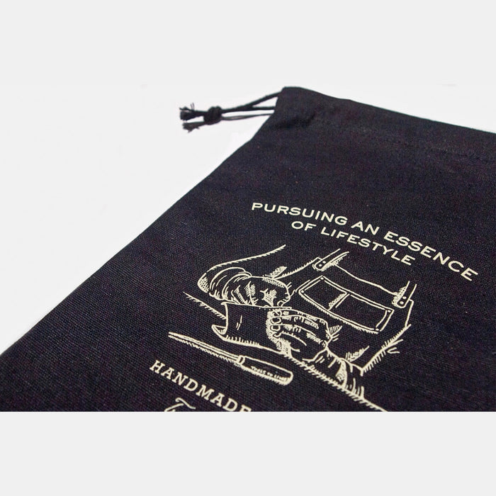Close-up of printed illustration and branding on black Tools To Live By canvas dust bag.