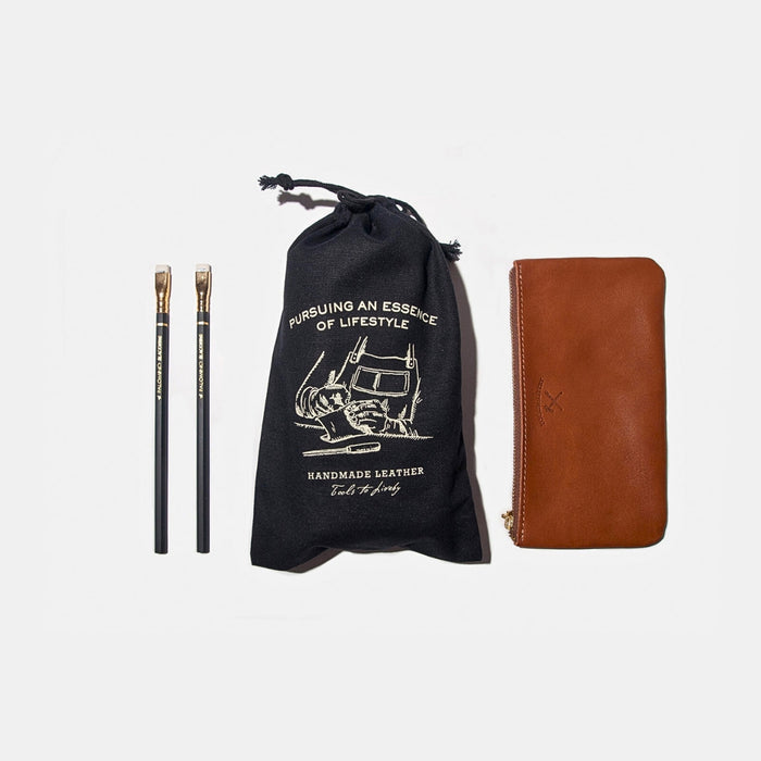Tools To Live By all purpose canvas dust bag displayed with leather zip case and pencils on a white background.