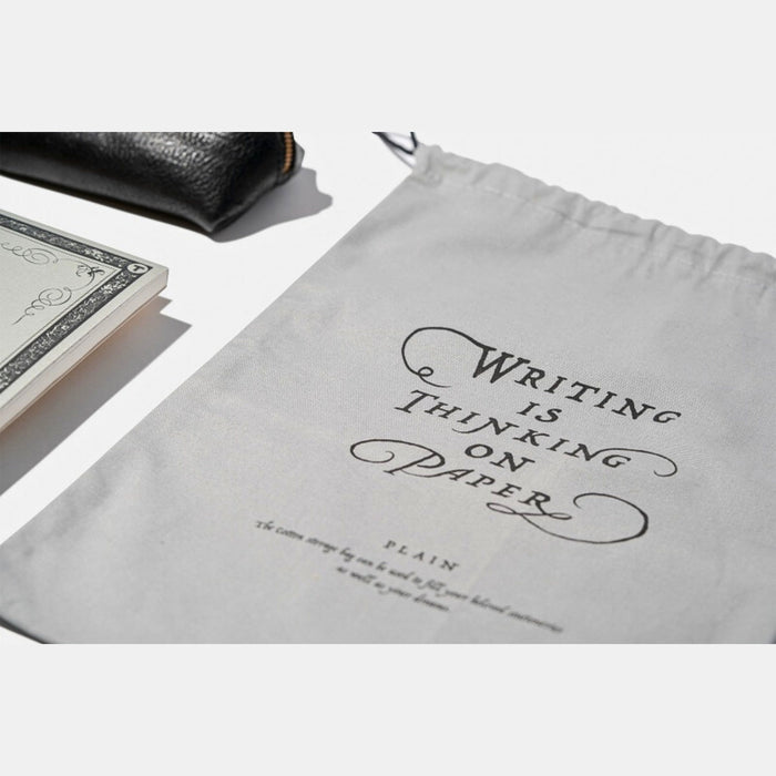 Close-up of printed logo and fabric texture on Tools To Live By grey dust bag.