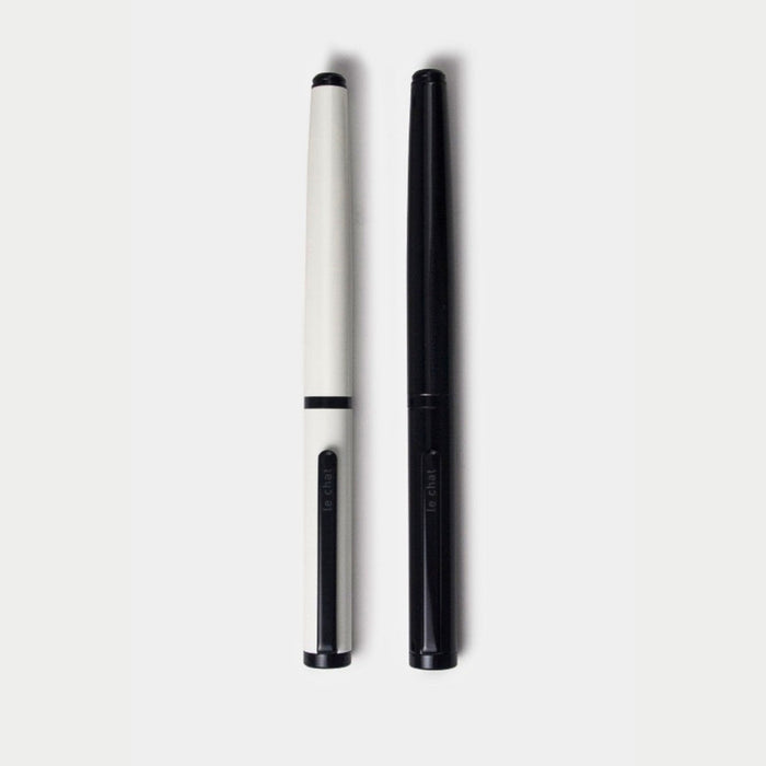 Black and white Tools to Live By Le Chat fountain pens shown side by side.