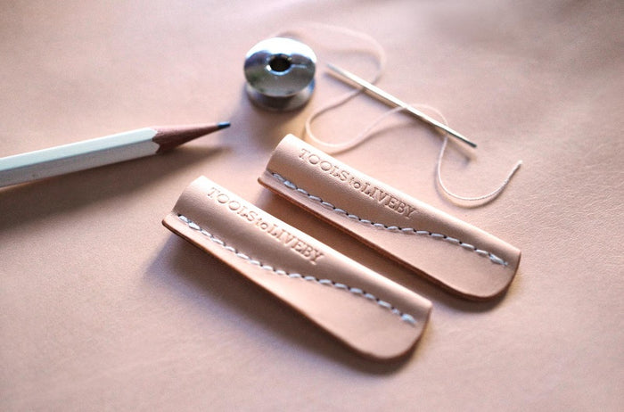 Tools to Live By leather pencil cap fitted onto a wooden pencil.