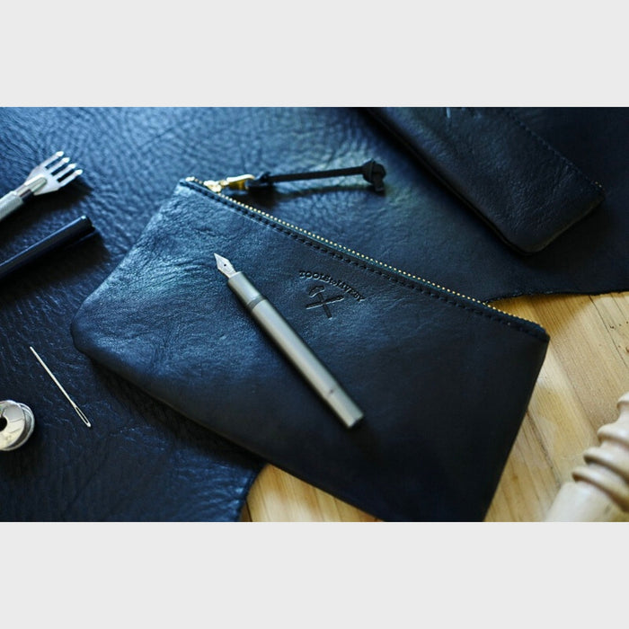Black (M) - Black Tools To Live By leather pen case styled with pens and writing accessories.