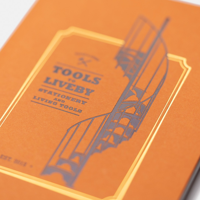 Close-up of Tools To Live By Spiral Staircase Grid Notebook cover showing printed illustration