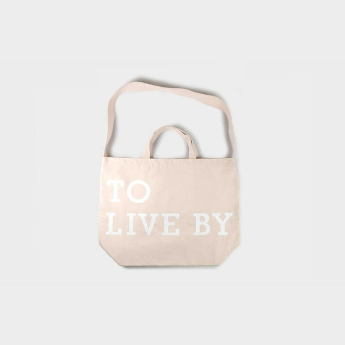 Beige Tools To Live By tote bag hanging, showing rear view and compact everyday size.