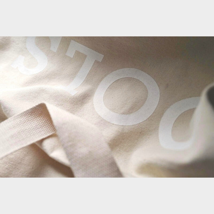 Detail of beige canvas fabric and stitching on Tools To Live By tote bag.