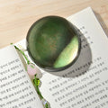 The Secret Garden - Green Wearingeul crystal ink paper weight shown on paper surface.