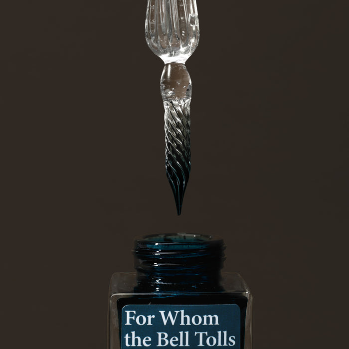Wearingeul glass pen dipped into ink bottle ready for writing.