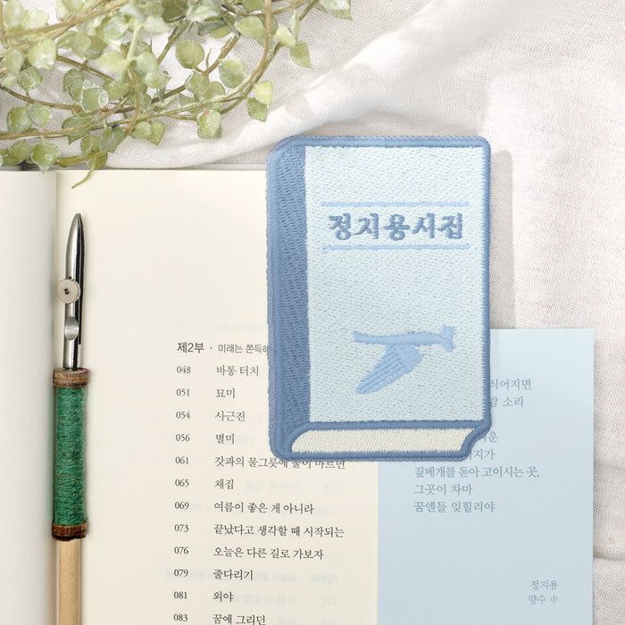 Wearingeul Korean Literature embroidery bookmark used as a page marker inside a book.