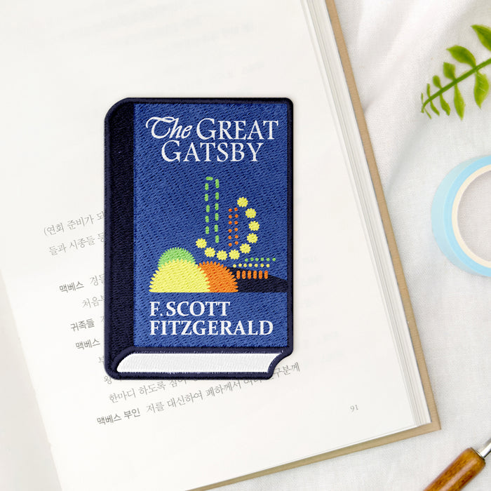 Wearingeul World Literature embroidered bookmark used in an open book for reading.