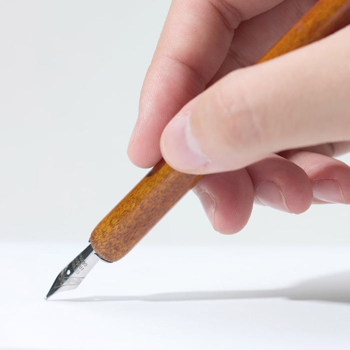 Wearingeul writer’s nib 40 mm being dipped into ink bottle.