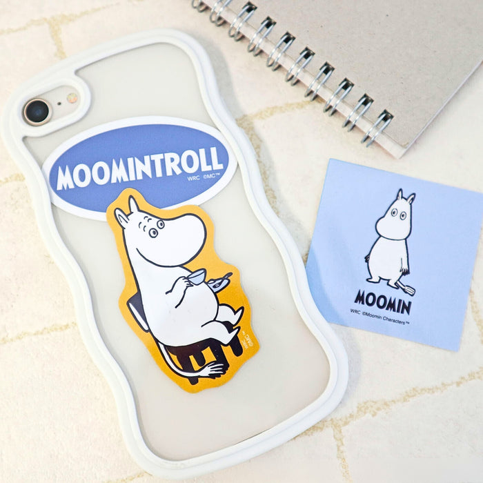 Moomintroll character sticker from the World Craft Moomin sticker set applied to a phone case, shown alongside a notebook and Moomin card.